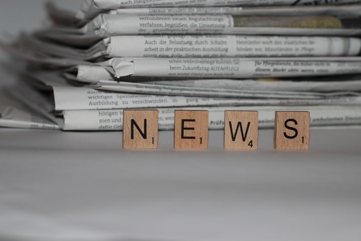 Holzbuchstaben NEWS vor Zeitungen, auf den Newsletter von Natalie Kitterer Bezug nehmen